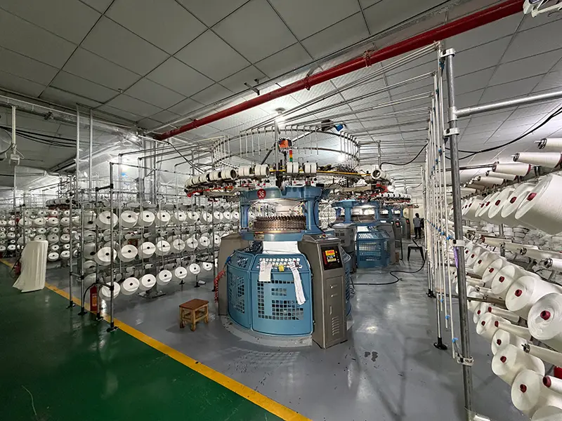 MUYUE Textile fabric production workshop with knitting machines and yarn rolls